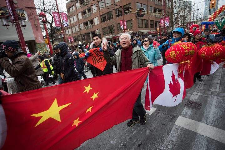 People carry Chinese and Canadian flags while marching in the Chinese New Year Parade in Vancouver.