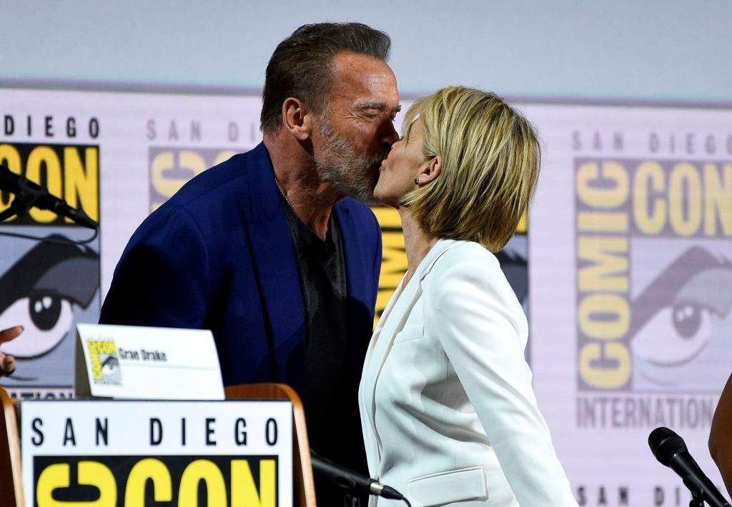 Arnold Schwarzenegger, left, and Linda Hamilton kiss at the ‘Terminator: Dark Fate’ panel on Day 1 of Comic-Con International on Thursday, July 18, 2019, in San Diego. (Photo by Chris Pizzello/Invision/AP)