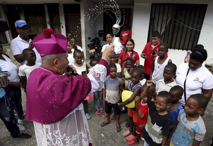 Catholic Bishop Ruben Dario Jaramillo Montoya sprinkles holy water on children in Buenaventura, Colombia, Saturday, July 13, 2019.
