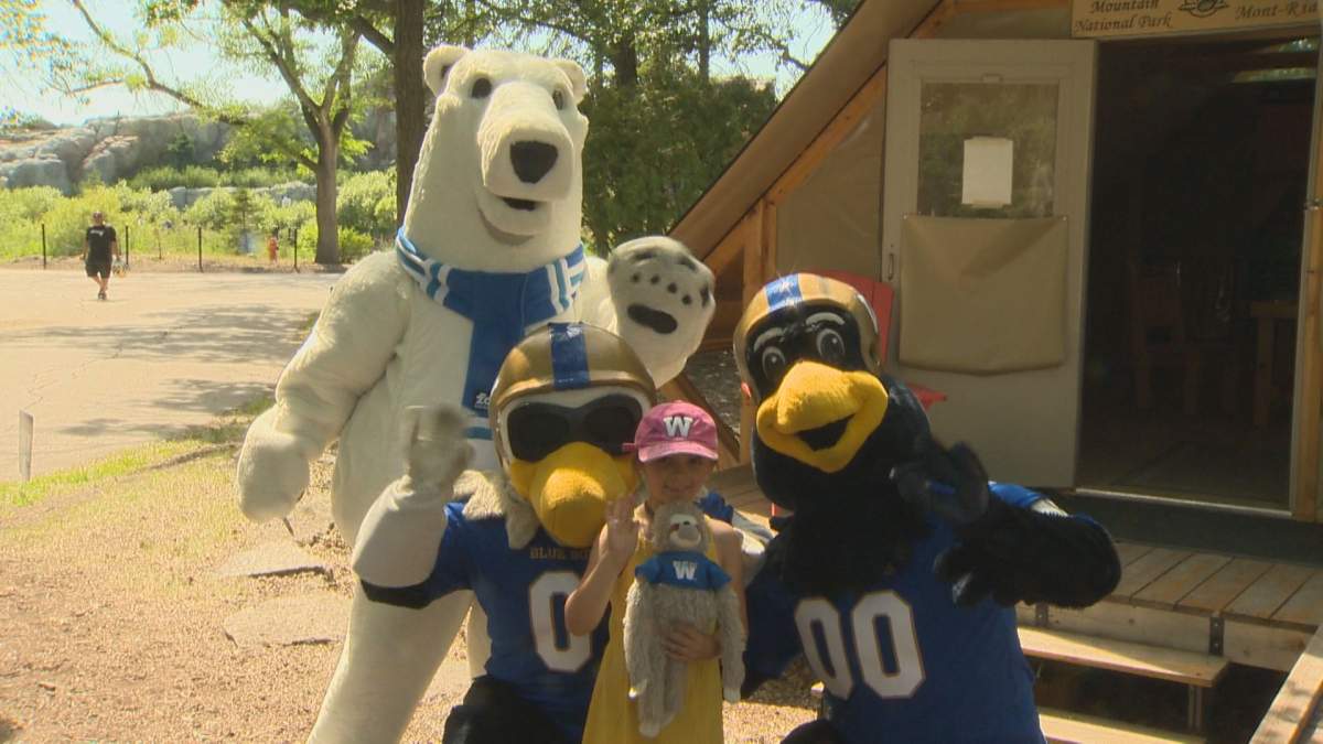 Winnipeg Blue Bombers mascots pose with a child at the Assiniboine Park Zoo on Sunday, July 7, 2019.