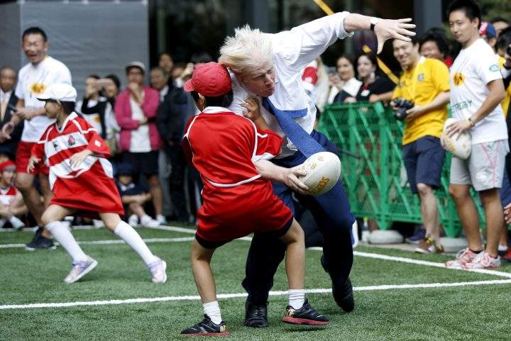 London’s Mayor Boris Johnson collides with 10-year-old Toki Sekiguchi during a game of Street Rugby with a group of Tokyo children, outside the Tokyo Square Gardens building October 15, 2015.