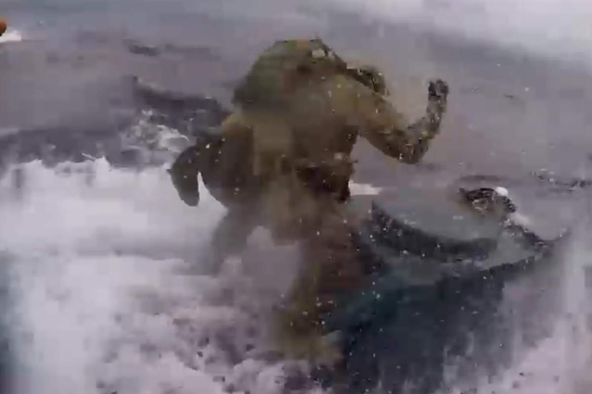An officer with the U.S. Coast Guard boards a semi-submersible full of suspected drug smugglers on the Pacific Ocean on June 18, 2019.