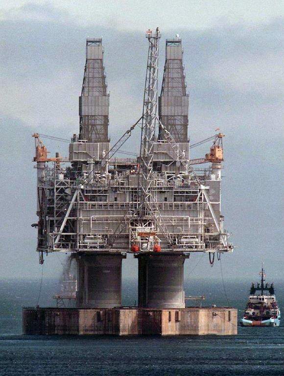 A tug positions itself near the base of the Hibernia platform in Bull Arm, Trinity Bay, Nfld., on May 22, 1997. Efforts continue off Newfoundland's east coast to monitor and clean up oil remaining from the estimated 12,000 litres that spilled from the Hibernia platform last week.