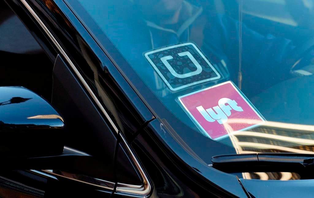 A ride share car displays Lyft and Uber stickers on its front windshield in downtown Los Angeles. So far in B.C. the two major players have only applied to provide service in the Lower Mainland region.