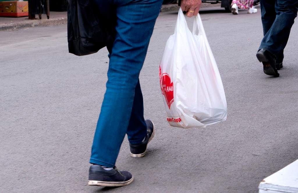 A woman carries a plastic bag at a market in Montreal on June 13, 2019. British Columbia's top court has quashed a bylaw prohibiting single-use plastic bags in Victoria, saying the city failed to get the approval of the province's environment minister.THE CANADIAN PRESS/Paul Chiasson.