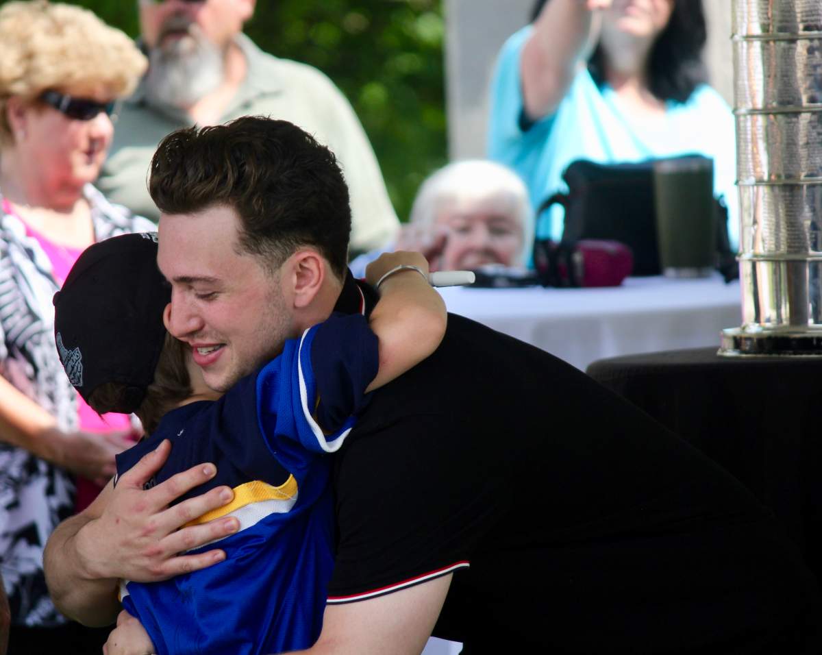 St. Louis Blues’ defenceman Vince Dunn hugs a fan at Old Mill Park in Lindsay on Saturday.