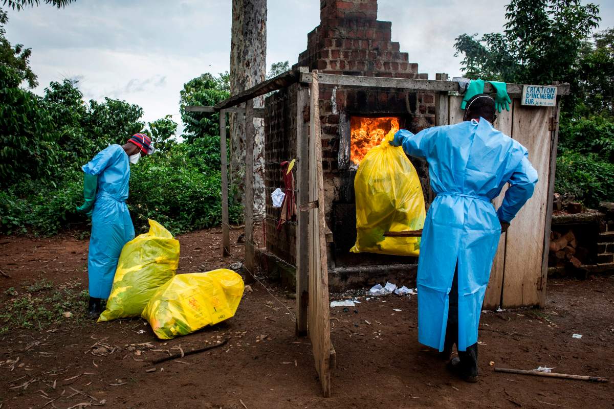Health workers burn medical waste generated during care of patients with Ebola virus, on August 21, 2018 in Mangina, near Beni, in the North Kivu province.