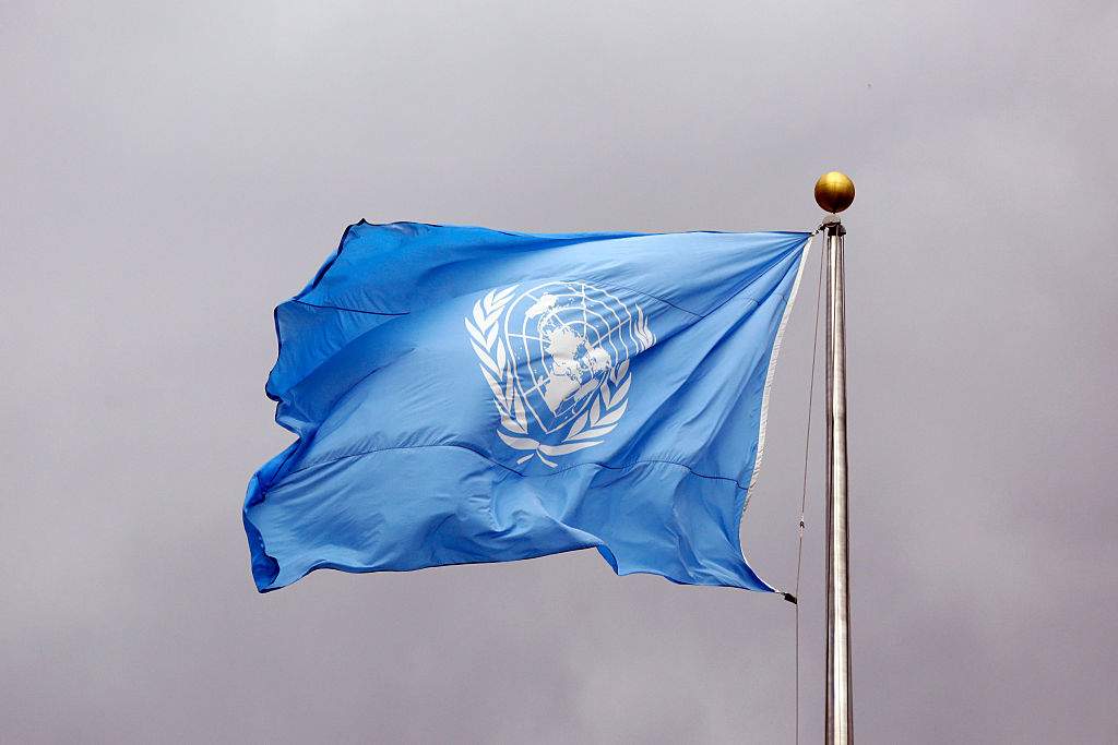 NEW YORK CITY, UNITED STATES - SEPTEMBER 24: Flag of the United Nations in front of grey clouds on top of the United Nations Secretariat at the headquarters of the United Nations on September 24, 2014, in New York City, United States. 