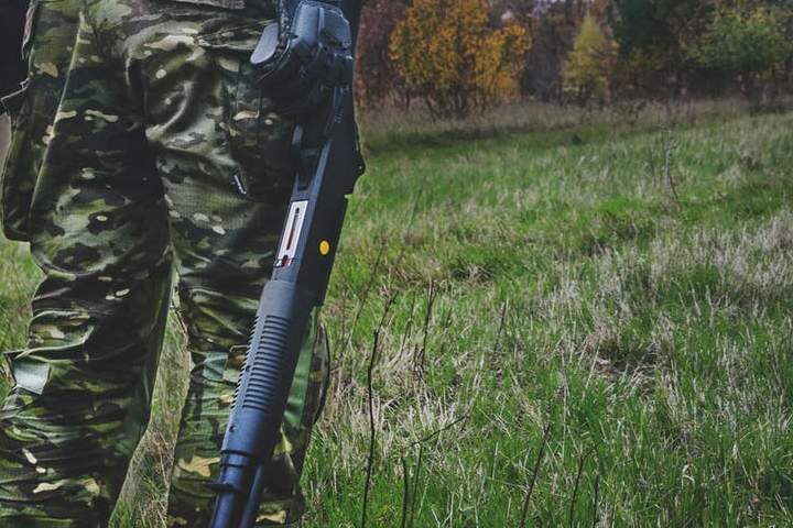 A hunter is shown with a shotgun at his side in this file photo.