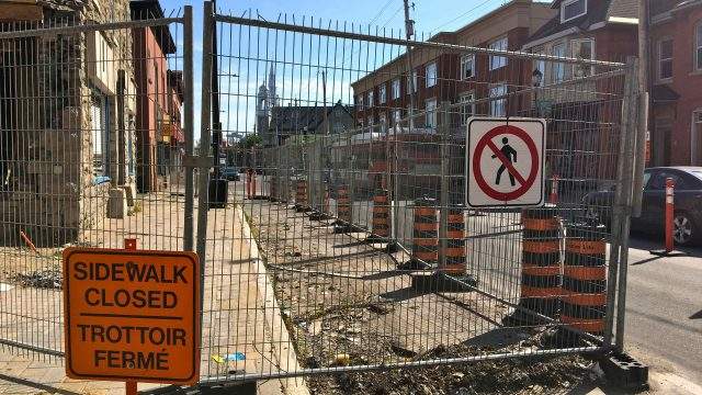 An image of the closed sidewalk and road in front of Magee House at 1119 Wellington St. W.