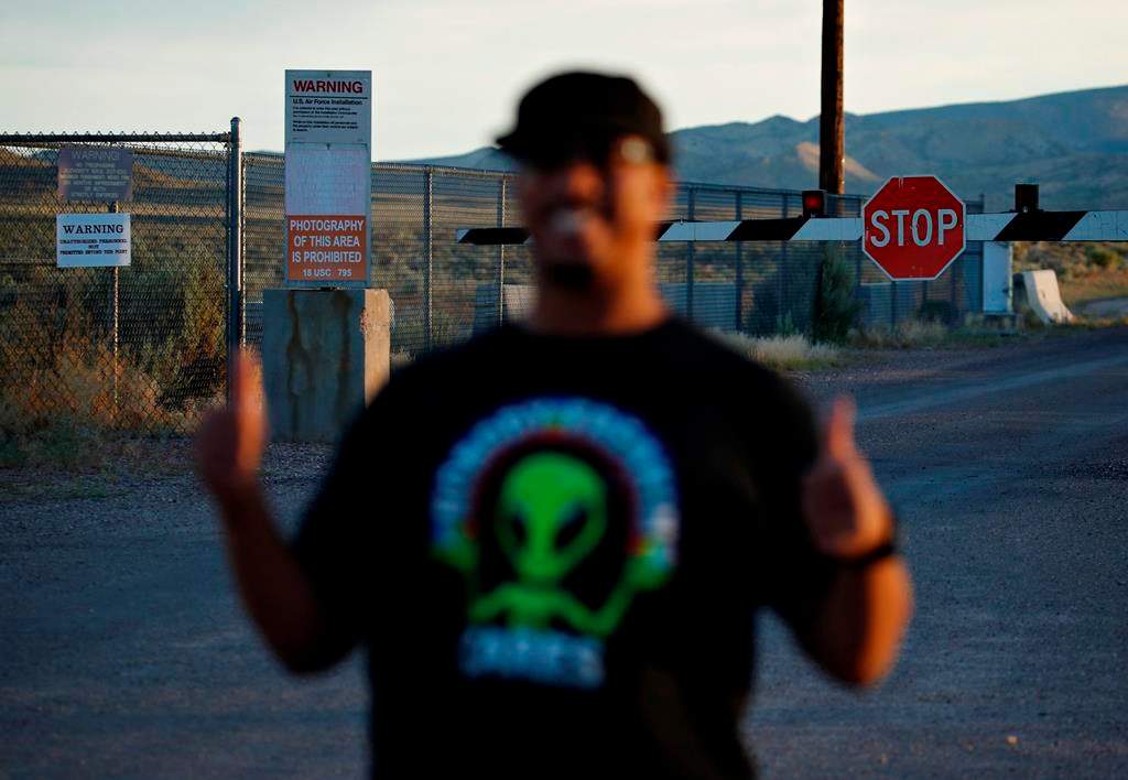 In this July 22, 2019 photo, Stan Evans poses as he has his picture taken while visiting an entrance to the Nevada Test and Training Range near Area 51 outside of Rachel, Nev. The U.S. Air Force has warned people against participating in an internet joke suggesting a large crowd of people “storm Area 51,” the top-secret Cold War test site in the Nevada desert. (AP Photo/John Locher)