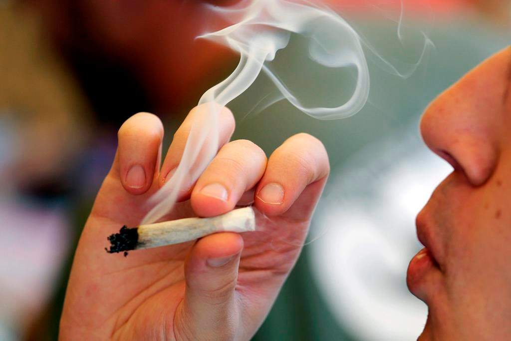 FILE - In this April 20, 2016, file photo, a man smokes a marijuana joint at a party.