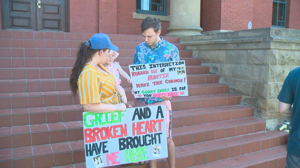 Briana Kelm with her family holding signs at a rally in Wetaskiwin.