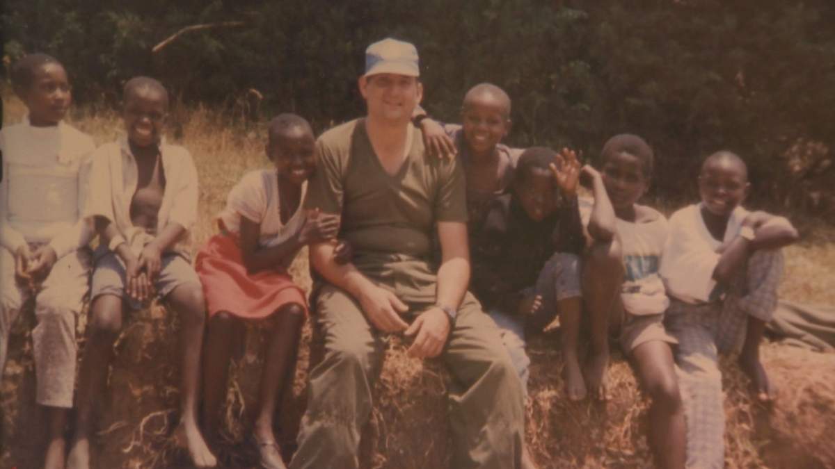 Warren Webber was a UN peacekeeper in Rwanda when this photo was taken. Sunday Justin Nzitatira is the second child from him with his hand up.