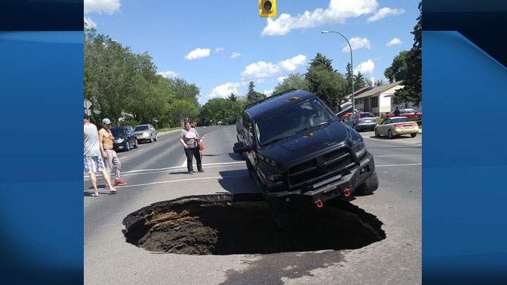 A vehicle, which was partially hung up on a sinkhole in Regina, was towed to safety on July 1, 2019.