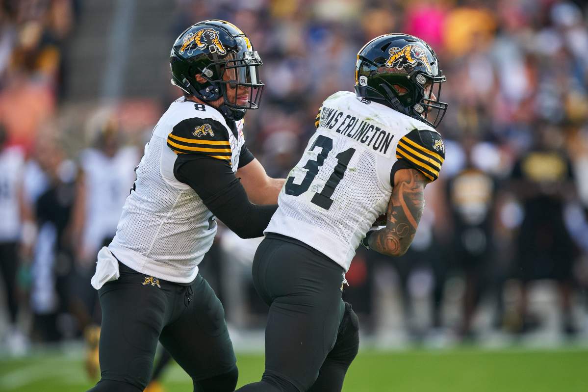 Hamilton Tiger-Cats quarterback Jeremiah Masoli hands off to Sean Thomas Erlington (31) during third quarter CFL action between the Ticats  and the Toronto Argonauts in Toronto on Saturday June 22, 2019.
