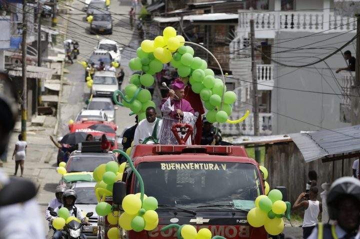Catholic Bishop Ruben Dario Jaramillo Montoya rides on a fire truck sprinkling holy water in Buenaventura, Colombia, Saturday, July 13, 2019. 