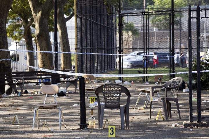 Yellow evidence markers are placed next to chairs at a playground in the Brownsville neighborhood in the Brooklyn borough of New York, Sunday, July 28, 2019.