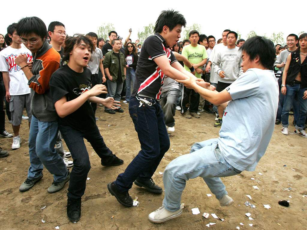 Chinese rock fans slam into each other in a makeshift outdoor mosh pit during a performance at the Midi Music Festival in Beijing, Wednesday, May 3, 2006.