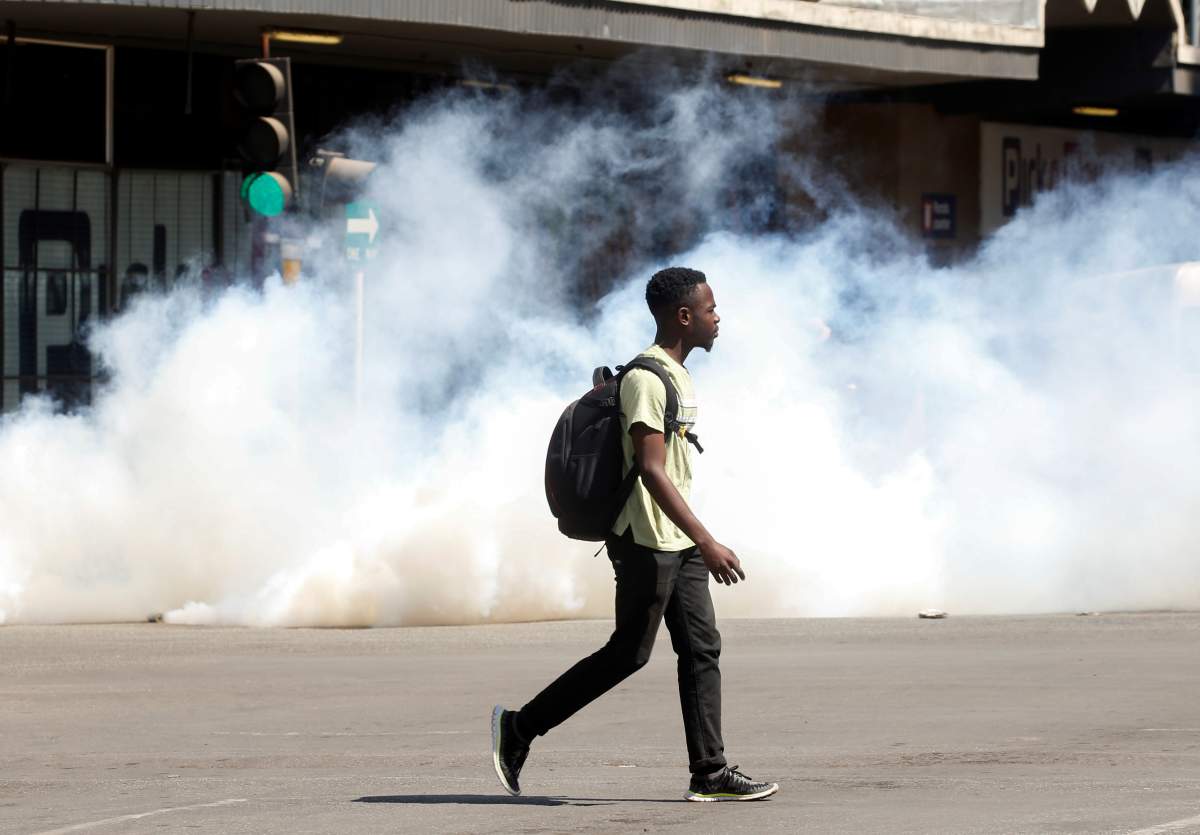 A man walks past clouds of teargas during clashes after police banned planned protests over austerity and rising living costs called by the opposition Movement for Democratic Change (MDC) party in Harare, Zimbabwe, August 16, 2019.REUTERS/Philimon Bulawayo