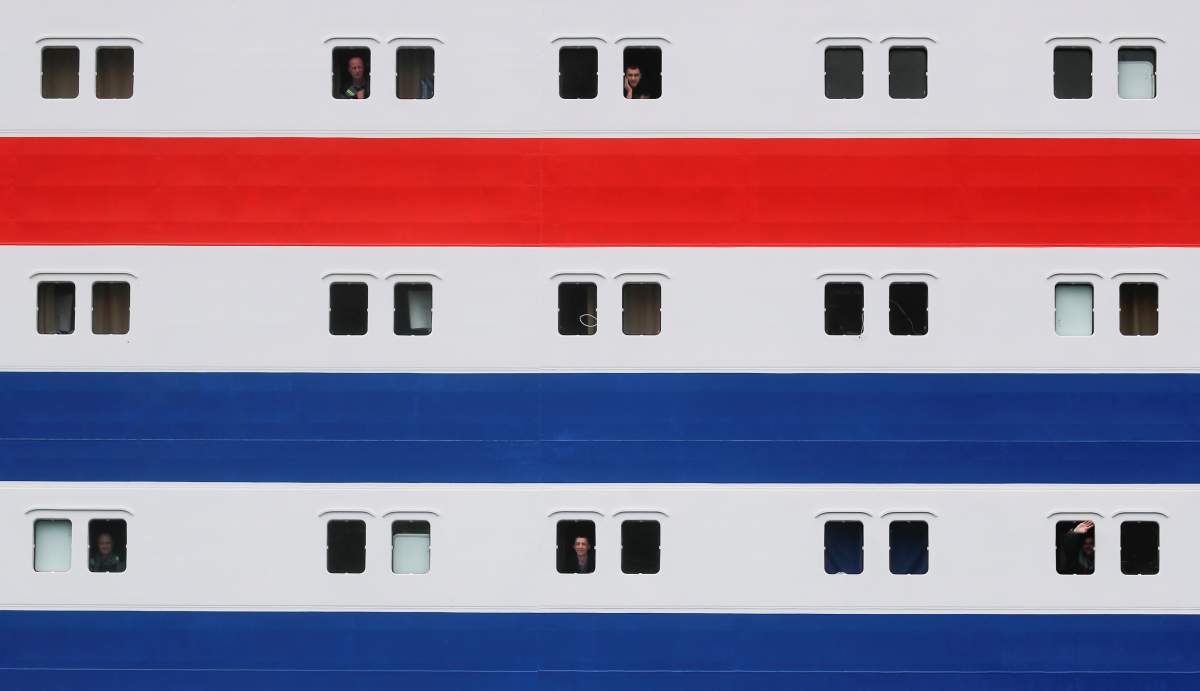 Employees and crew members look out of the windows of Russia’s floating nuclear power plant Akademik Lomonosov as it leaves the service base of Rosatomflot company for a journey along the Northern Sea Route to Chukotka from Murmansk, Russia August 23, 2019. REUTERS/Maxim Shemetov