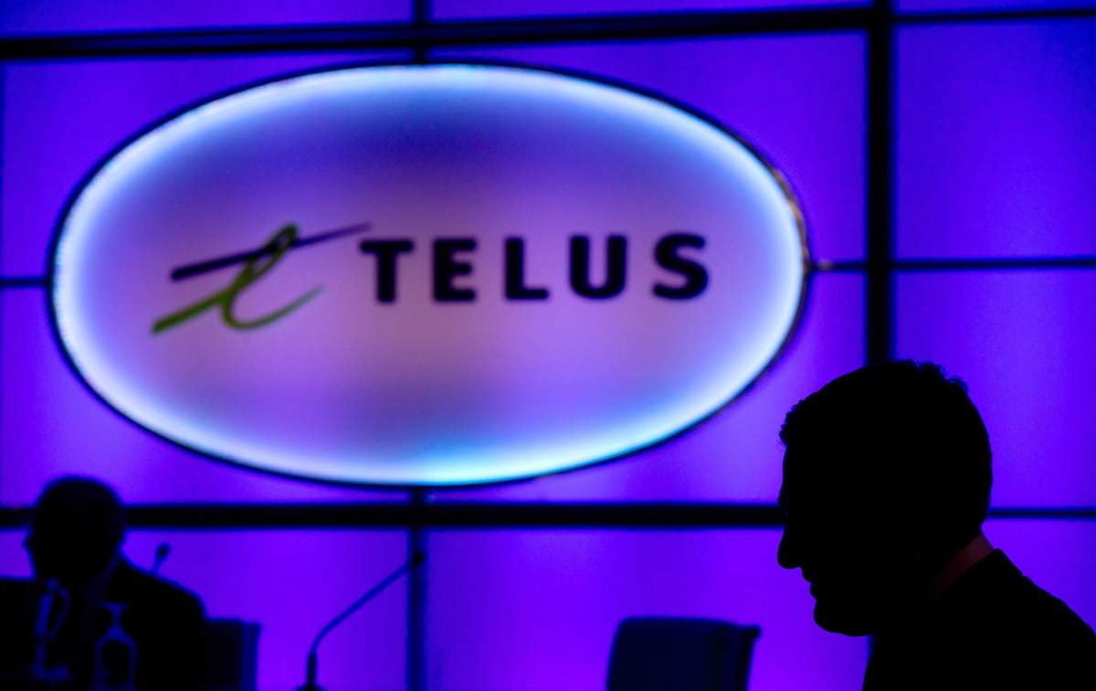 People are silhouetted at the telecom company's annual general meeting in Vancouver on May 8, 2014. Telus is the latest Canadian wireless provider to offer unlimited amounts of data for a fixed monthly price, another indication that the industry is changing how it does business. 
