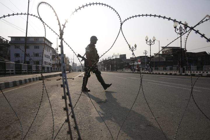 Indian paramilitary soldiers stand guard near barbed wire during restriction in Srinagar, the summer capital of Indian Kashmir, 05 August 2019 (issued 06 August 2019).  Indian Home Minister Amit Shah moved a resolution in the parliament that repeals Article 370, and said the state will be split into two Union Territories, Kashmir with an Assembly and Ladakh region without one.  
