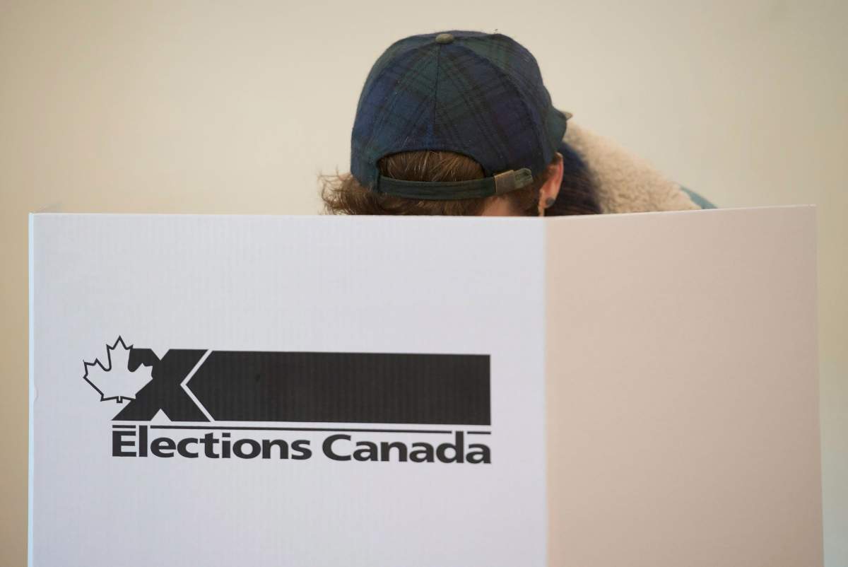 A voter marks a ballot behind a privacy barrier in the riding of Vaudreuil-Soulanges, west of Montreal, on election day, Monday, Oct. 19, 2015. Refugees in 2015, some Syrians are now citizens in time to vote in the 2019 federal election.