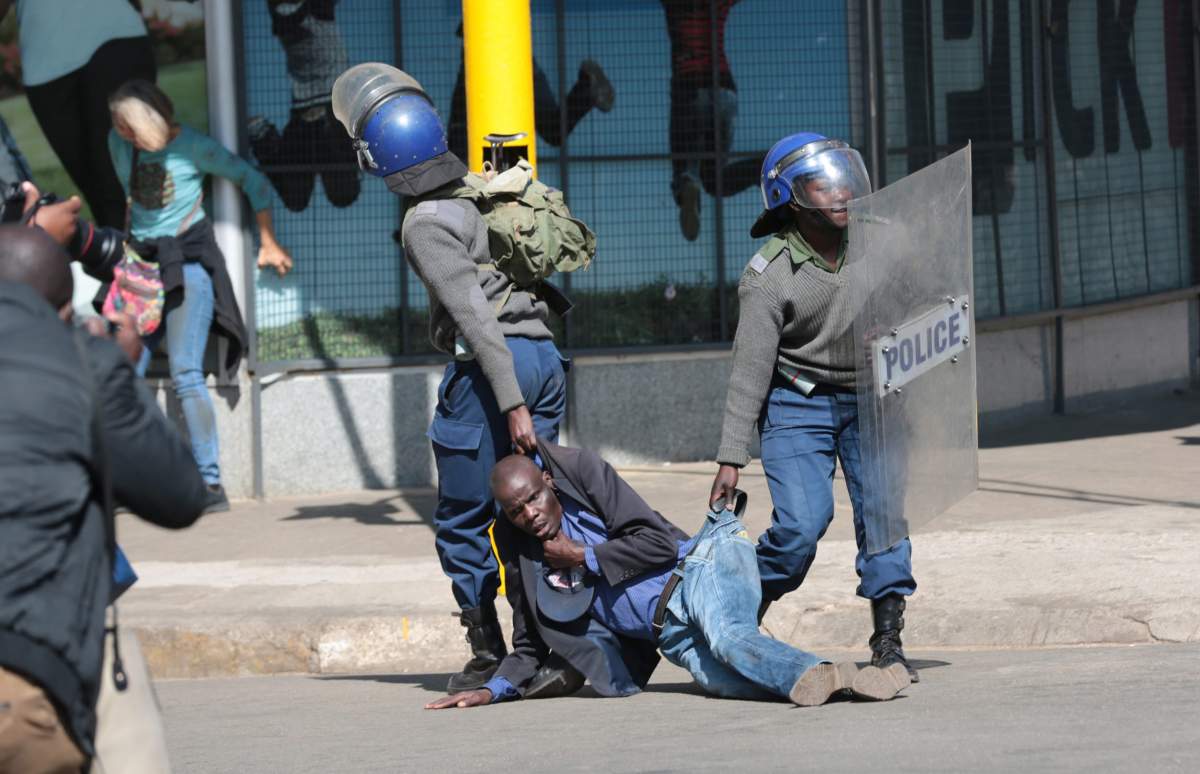 Zimbabwe Republic Police (ZRP) drag an injured protester during clashes with members of the public who took part in the Democratic Change (MDC) Alliance organised Peace March in Harare, Zimbabwe, 16 August 2019