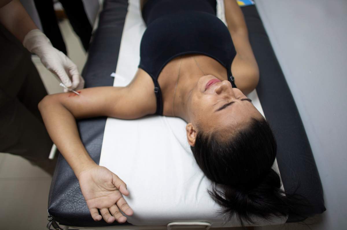 In this photo taken July 25, 2019, 18-year-old Yorselis Fajardo, who became a mother when she was 15, gets a hormonal implant on her arm to prevent pregnancies at a clinic in the Caucaguita neighborhood on the outskirts of Caracas, Venezuela.