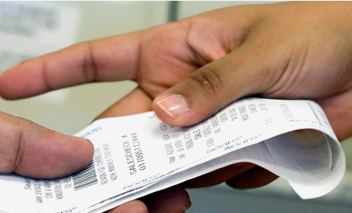 A cashier hands a customer his change and receipt during a purchase transaction at a store, in Henderson, Nev. on Aug. 29, 2014. 