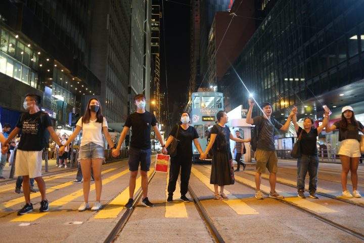 Protesters hold hands as they participate in the ‘Hong Kong Way’ in Hong Kong, Aug. 23, 2019.