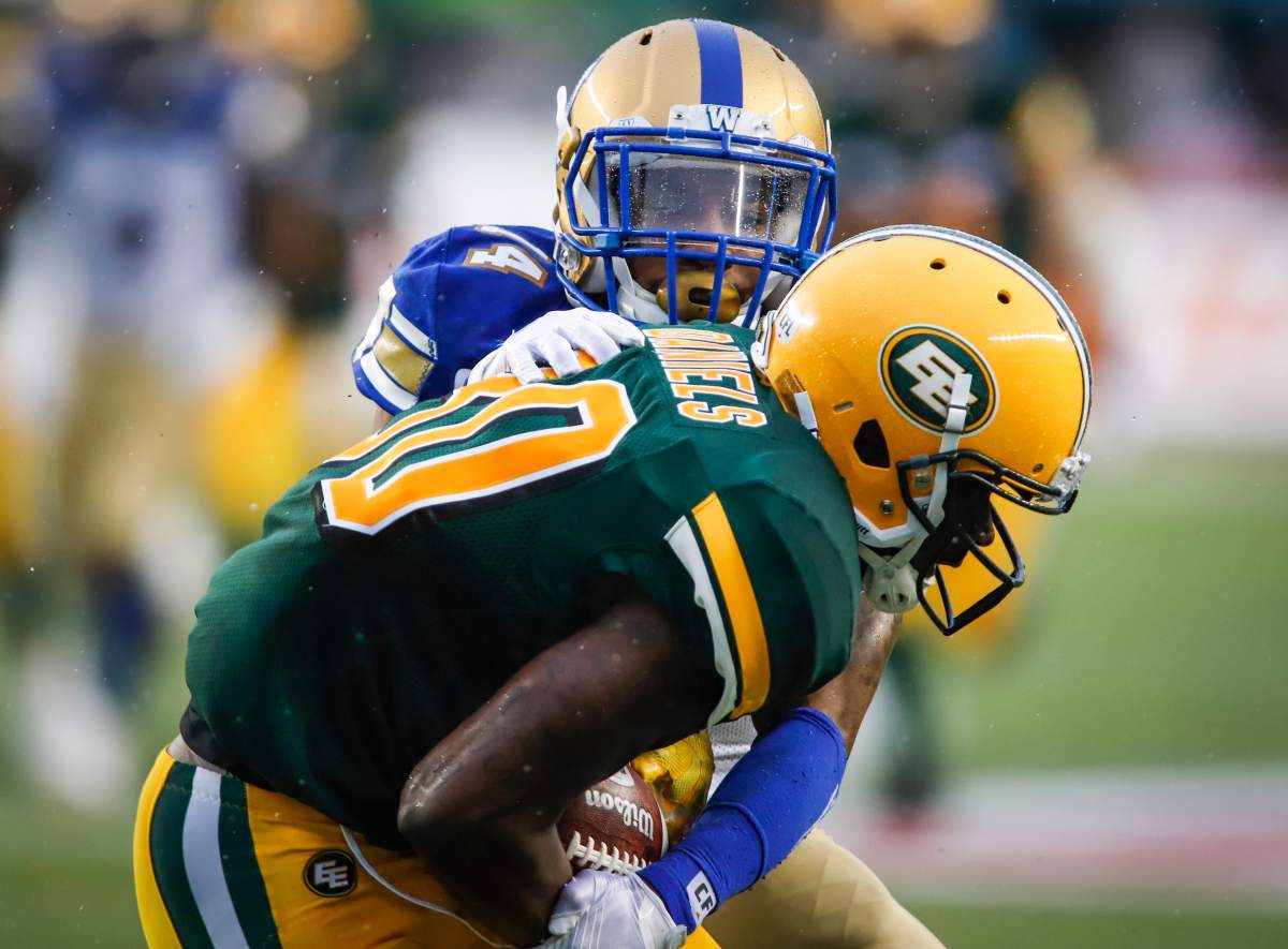 Winnipeg Blue Bombers' Marcus Sayles, left, tries to strip Edmonton Eskimos' DaVaris Daniels of the ball during first half CFL football action in Edmonton, Friday, Aug. 23, 2019.