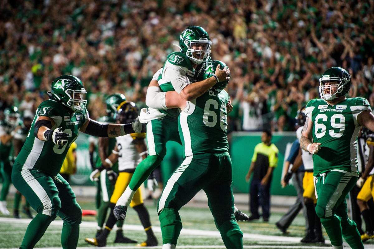 Saskatchewan Roughriders quarterback Cody Fajardo (7) celebrates his touchdown with Saskatchewan Roughriders offensive lineman Dariusz Bladek (66) during second half CFL action in Regina on Thursday.