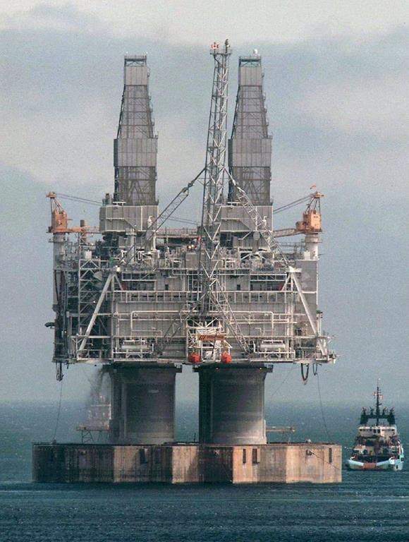A tug positions itself near the base of the Hibernia platform in Bull Arm, Trinity Bay, N.L., Thursday, May 22, 1997.