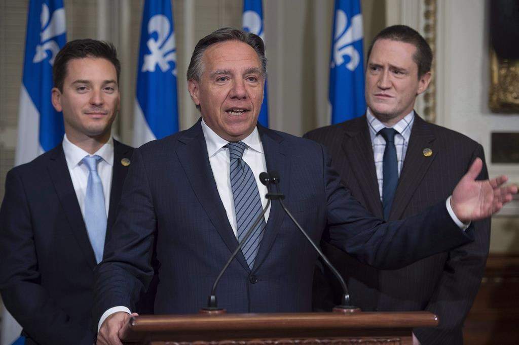 Coalition Avenir Quebec Leader Francois Legault speaks to reporters at a news conference prior to a party caucus meeting at the legislature in Quebec City, Oct. 19, 2016. MNAs Simon Jolin-Barrette, left, and Benoit Charrette look on. THE CANADIAN PRESS/Jacques Boissinot.