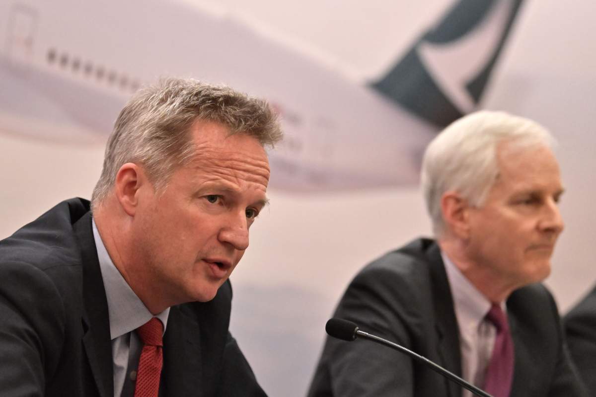 Cathay Pacific's chief executive officer Rupert Hogg (L) speaks next to chairman John Slosar during a press conference following the release of the company's annual results in Hong Kong on March 13, 2019.  