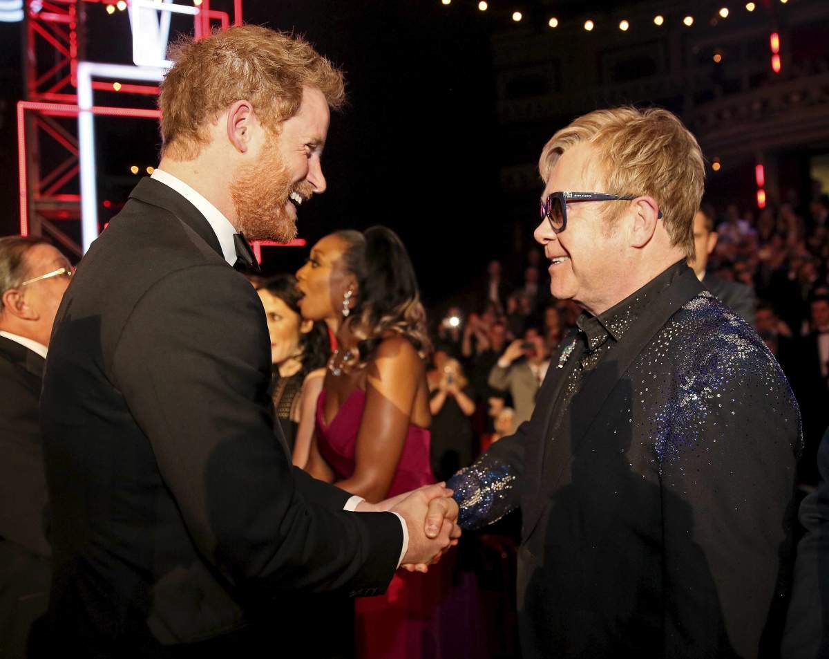 Britain's Prince Harry (L) greets British musician Elton John (R) at the Royal Variety Performance at the Royal Albert Hall in London on November 13, 2015.
