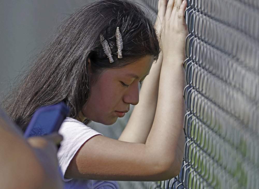 This young woman cries while standing outside the Koch Foods Inc., plant as U.S. immigration officials raid the plant in Morton, Miss., Wednesday, Aug. 7, 2019.