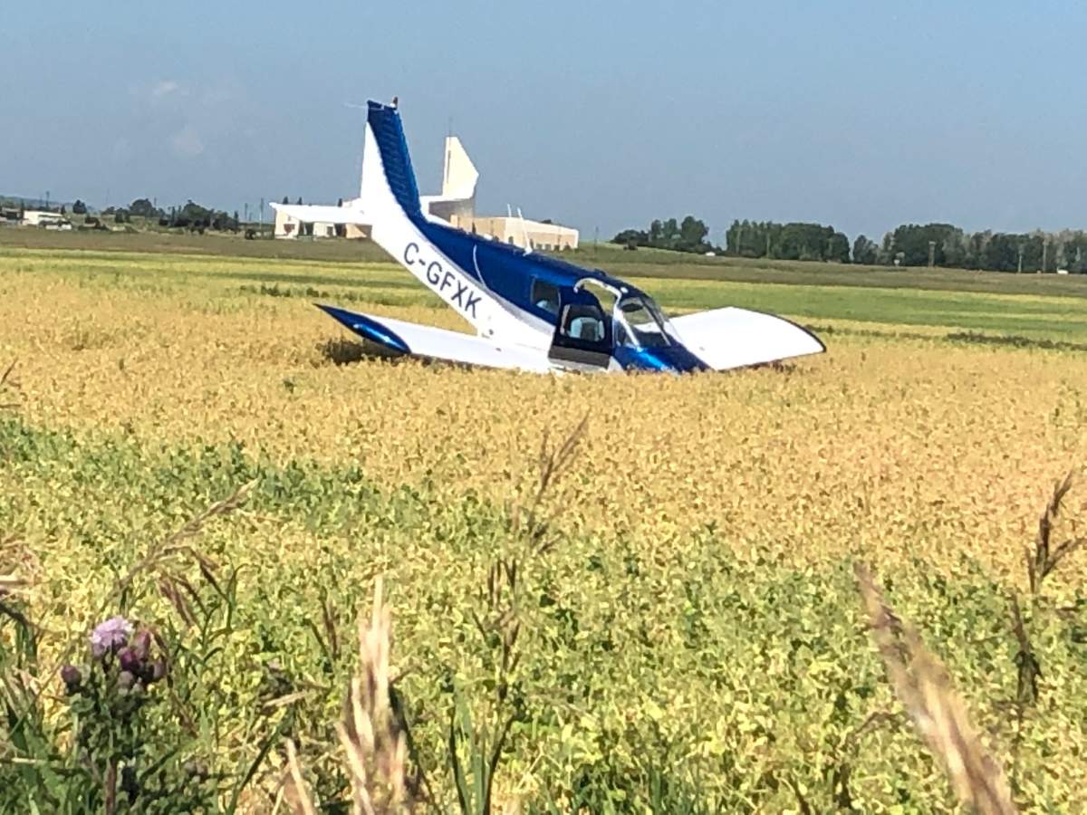 A small airplane is seen nose-down in an Okotoks field following a crash landing on Thursday, Aug. 8, 2019.