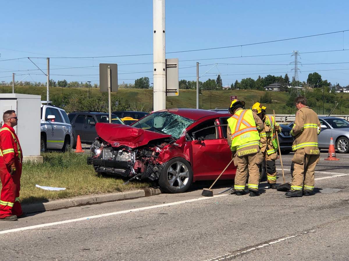 Firefighters help clean up the scene of a crash on Memorial Drive on Thursday, Aug. 15.