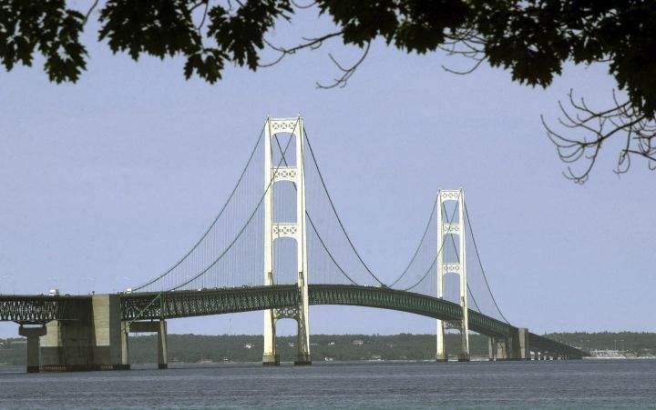 FILE - This July 19, 2002, file photo, shows the Mackinac Bridge that spans the Straits of Mackinac from Mackinaw City, Mich. Oil transport company Enbridge says Wednesday, a gap has opened between a section of its Line 5 pipeline and the lake bottom in Michigan's Straits of Mackinac. Erosion has washed away sediments beneath the pipeline, opening a gap that exceeds the 75-foot limit set under a state easement. The company says it's awaiting government permits to install screw anchors for additional support in that spot and others along the underwater line.
