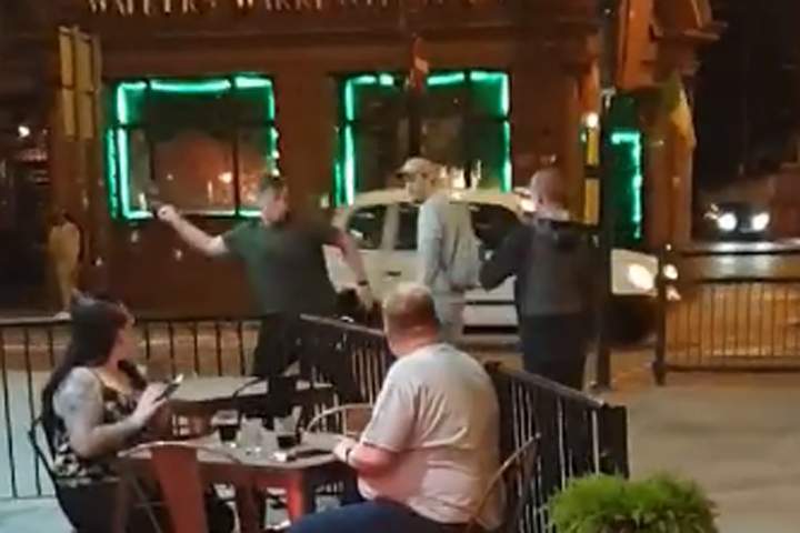 One man, left, throws a dead pigeon at his assailant, right, in this image from video recorded in Liverpool, U.K.
