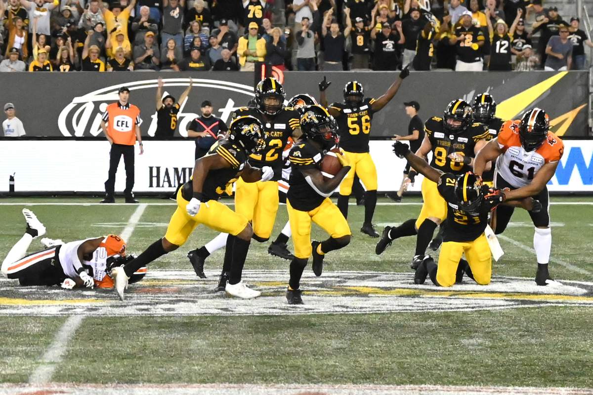Hamilton Tiger-Cats' defensive back Richard Leonard, centre, runs back his interception in the final minute against the BC Lions during second half CFL football game action in Hamilton, Ontario on Saturday, August 10, 2019.