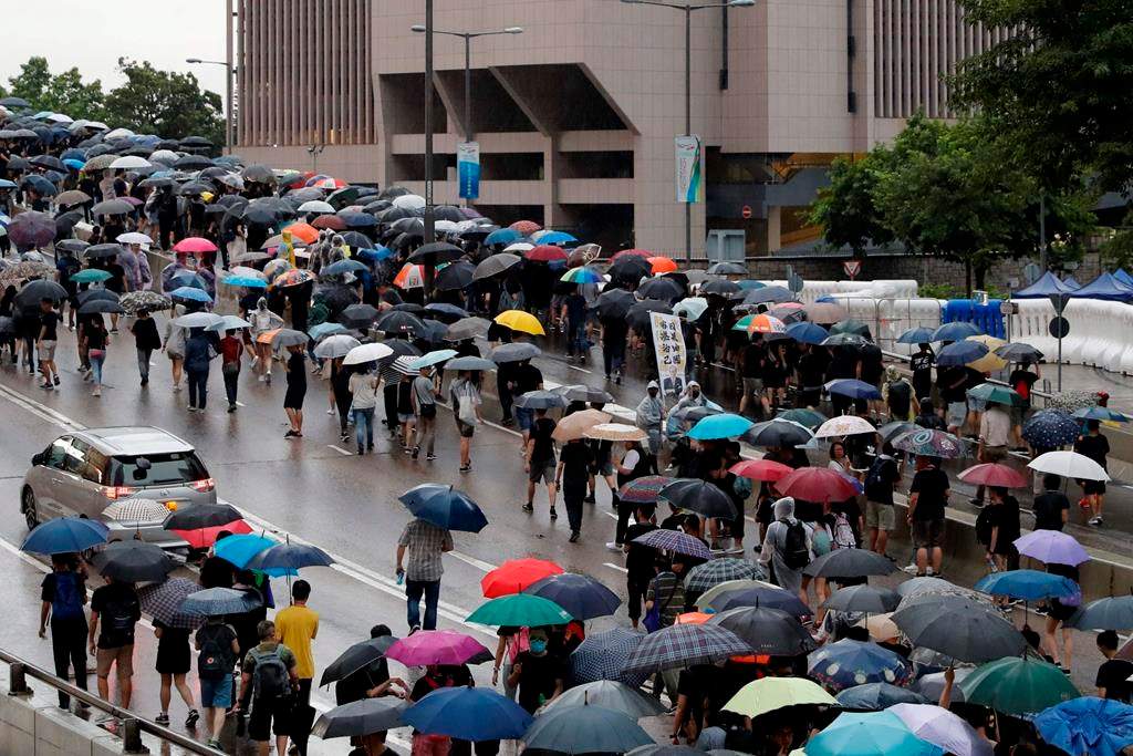 Protesters march in the rain in Hong Kong Sunday, Aug. 18, 2019. Heavy rain fell on tens of thousands of umbrella-toting protesters Sunday as they marched from a packed park and filled a major road in Hong Kong, where mass pro-democracy demonstrations have become a regular weekend activity this summer. (AP Photo/Vincent Thian)