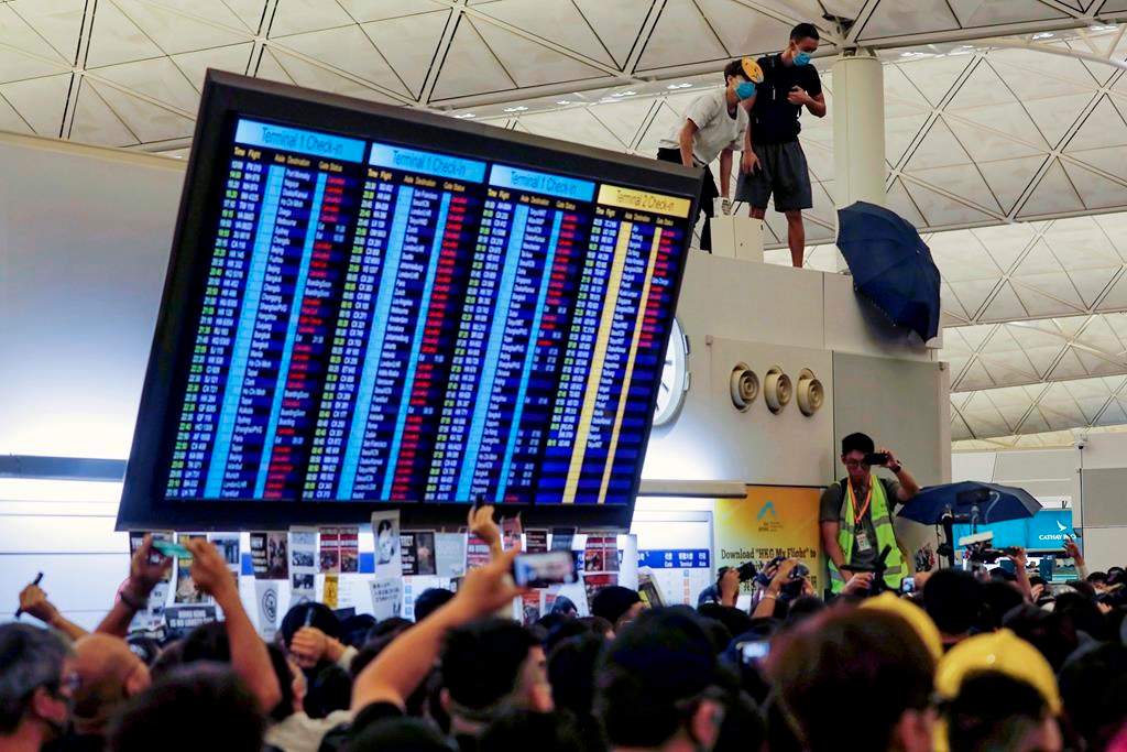 Protester use an umbrellas to block surveillance cameras during a demonstration at the Airport in Hong Kong, Tuesday, Aug. 13, 2019. Prominent human rights activists and Chinese political dissidents warned Tuesday about the potential for a brutal crackdown on protesters in Hong Kong.