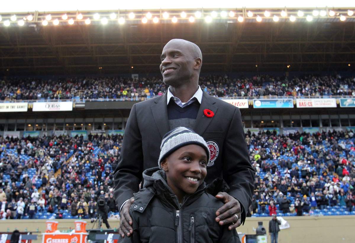 Milt Stegall with his son, Chase, during a ceremony for the hall of fame inductees at half-time in CFL action between the Winnipeg Blue Bombers and the Montreal Alouettes in Winnipeg on Nov. 3, 2012. (CFL PHOTO – Marianne Helm)