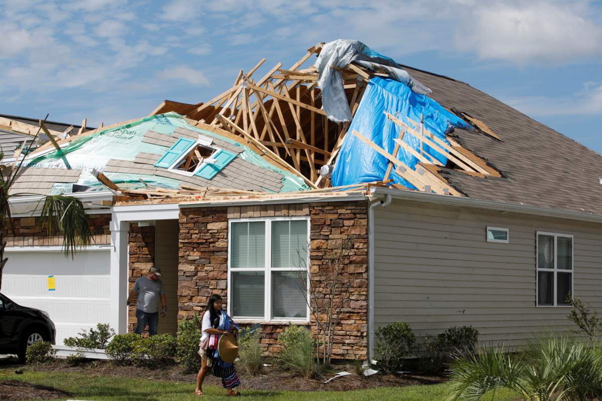 A girl removes personal belongings from her damaged home after a tornado spawned by hurricane Dorian ripped apart her roof in Carolina Shores, North Carolina, U.S. (Reuters)
