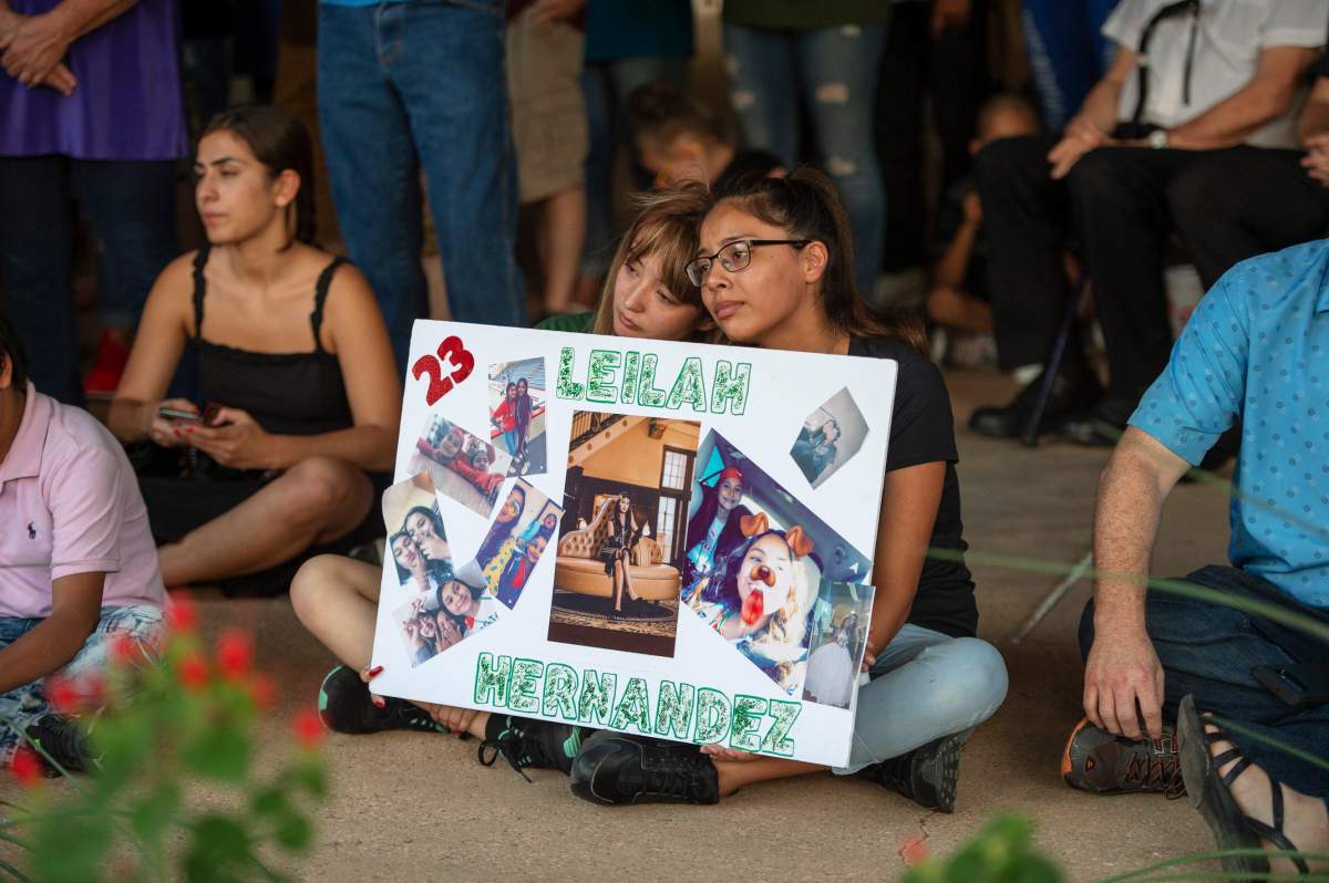 Celeste Lujan, left, and Yasmin Natera hold a sign in honour of Leilah Hernandez during a vigil for victims of the shooting spree the day before, Sunday, Sept. 1, 2019, at the University of Texas of the Permian Basin quad, in Odessa, Texas.