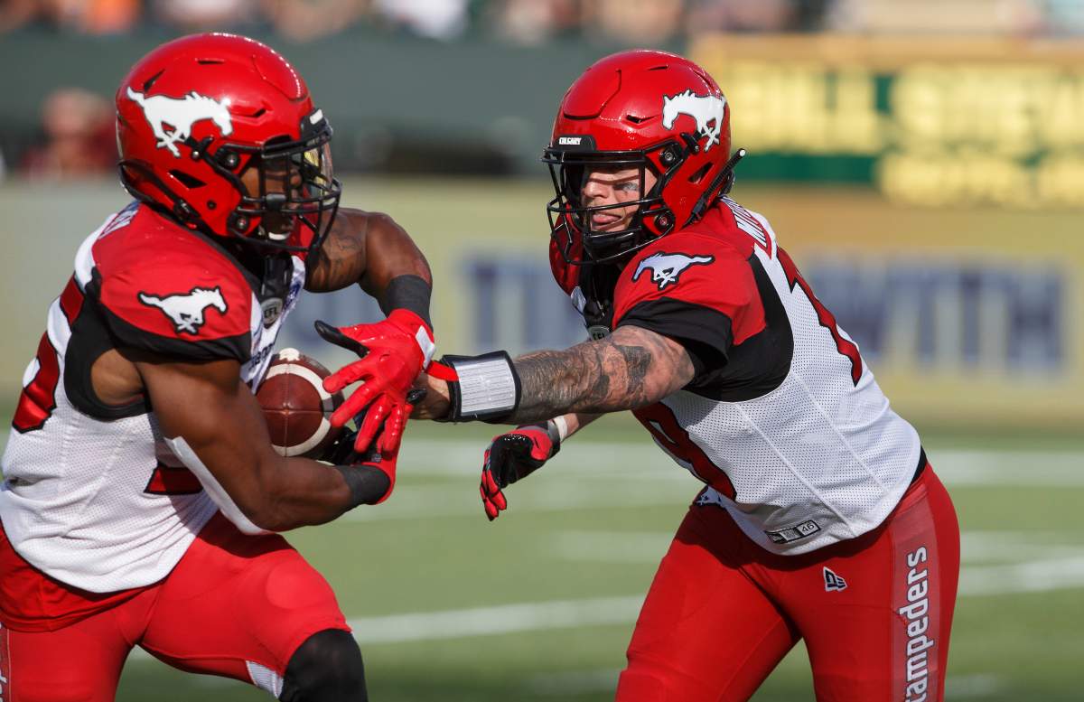 Calgary Stampeders quarterback Bo Levi Mitchell (19) hands off to Ka'Deem Carey (35) against the Edmonton Eskimos e during first half CFL action in Edmonton, Alta., on Saturday September 7, 2019. 